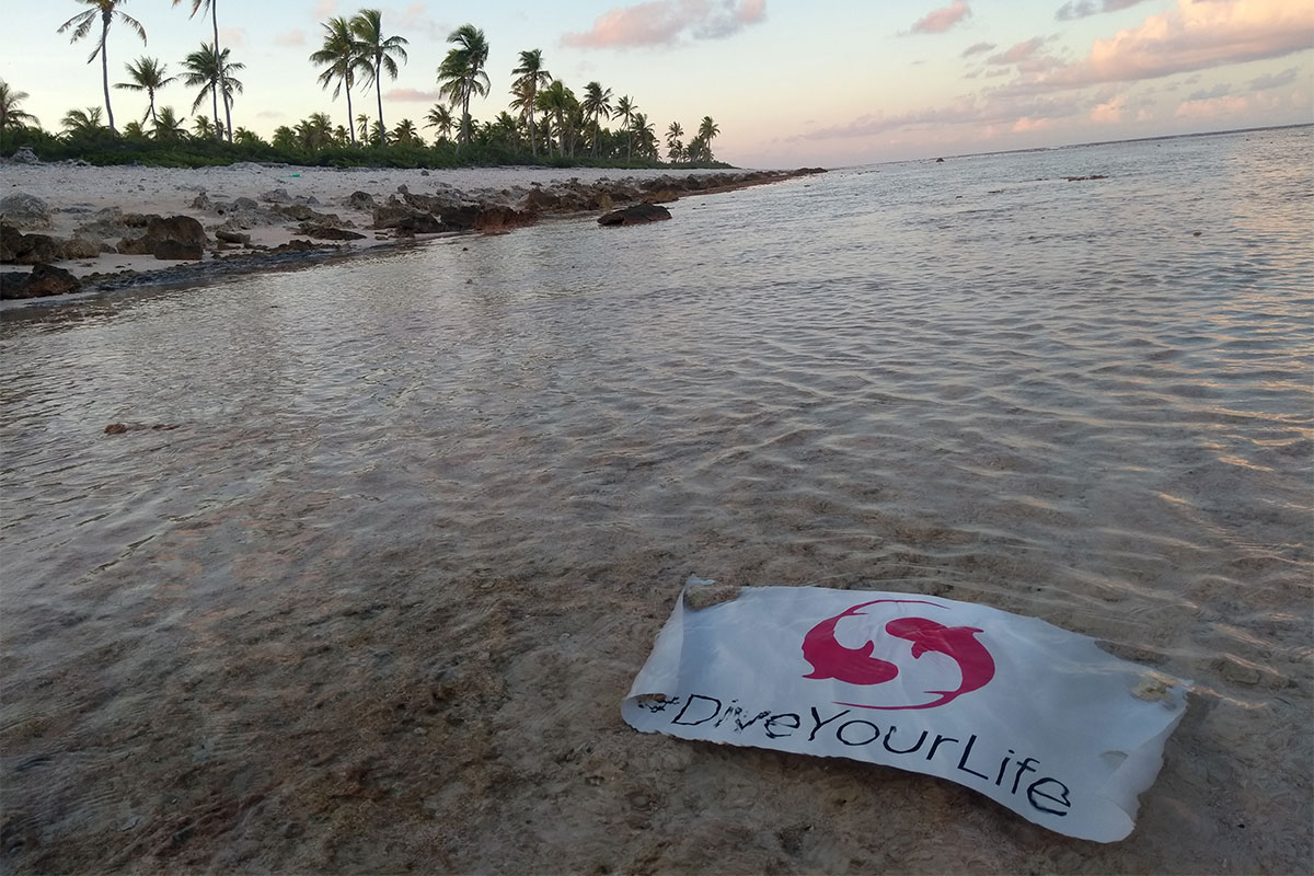 Bannière Subocea #DiveYourLife sur une plage de sable blanc à Ahé en Polynésie