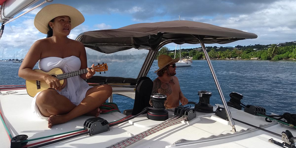 Polynésienne jouant du ukulele sur un bateau en Polynésie